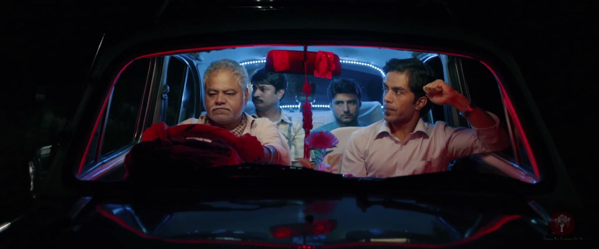 Firoz at the wheel of his taxi at night, the three brothers behind him